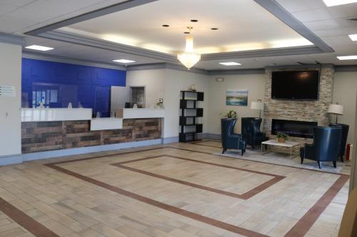 an office lobby with a fireplace and a tv at Bradley Inn in Windsor Locks