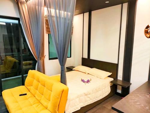 a bedroom with a bed and a yellow chair at CASA SAKURA Studio Vista Bangi with Wi-fi & Netflix in Kajang