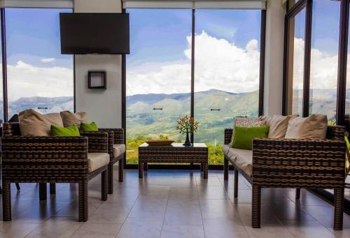 a room with chairs and a table and a large window at Casas Campestres Los Miradores de Fruworld in Carmen de Apicalá