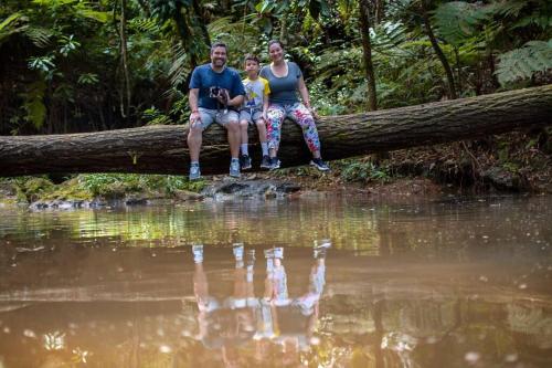 a man and woman sitting on a tree branch next to water at Casas Campestres Los Miradores de Fruworld in Carmen de Apicalá