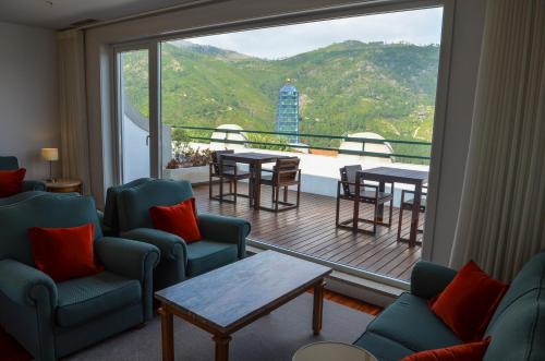 a room with chairs and tables and a large window at Hotel São Bento da Porta Aberta & Spa in Geres