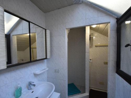 een witte badkamer met een douche en een wastafel bij Cozy Holiday Home with Small Garden in Trarego Piedmont in Trarego