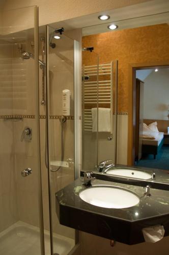 a bathroom with a sink and a shower at Domizil Alte Post in Püttlingen