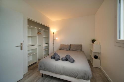 - une petite chambre avec un lit et un placard dans l'établissement Appartement tout équipé parking balcon 2 chambres, à Marseille