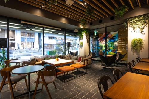 a restaurant with tables and chairs and windows at ibis Osaka Umeda in Osaka