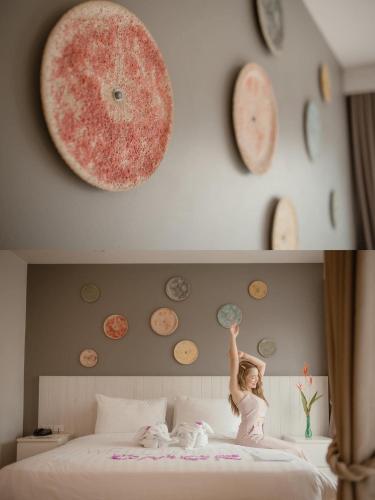 a little girl standing on a bed with a pizza on the wall at Cmor by Recall Hotels SHA Extra Plus in Chiang Mai