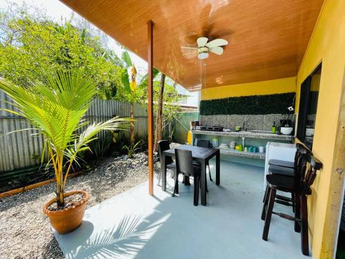 eine Terrasse mit einem Tisch, Stühlen und einer Pflanze in der Unterkunft Casa Nativa CR in Puerto Jiménez