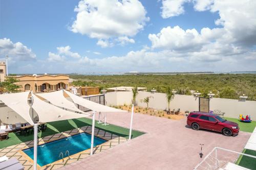a car parked in a parking lot next to a pool at Lazeemah Chalet استراحة اللزيمه in Ras al Khaimah