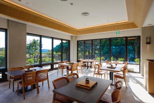 un restaurante con mesas, sillas y ventanas grandes en Samiling Resort en Checheng