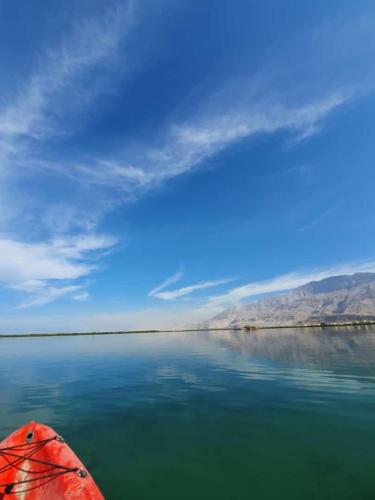 a red kayak on a body of water at Lazeemah Chalet استراحة اللزيمه in Ras al Khaimah