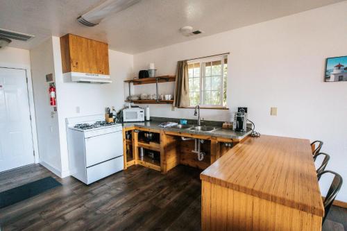 a kitchen with a refrigerator, stove, sink, and cabinets at View Crest Lodge in Trinidad