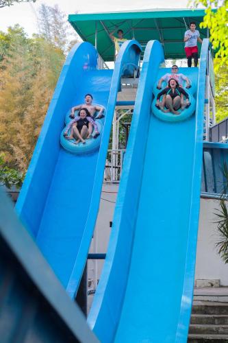 a group of people riding down a blue water slide at Whiterock Beach Hotel and Waterpark in Subic