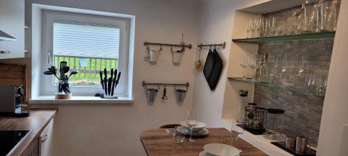 a kitchen with a table with wine glasses on the wall at Ferienwohnung Lohnerlehen in Marktschellenberg