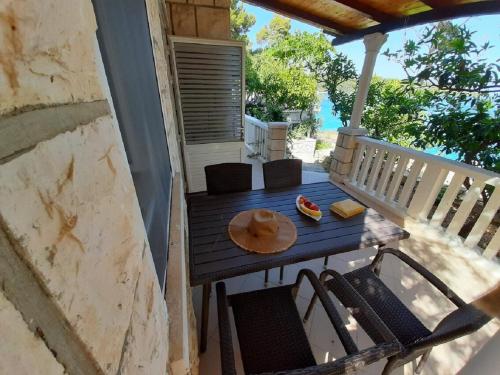 a porch with a table and chairs on a balcony at Apartments Rud - 15 m from sea in Lumbarda