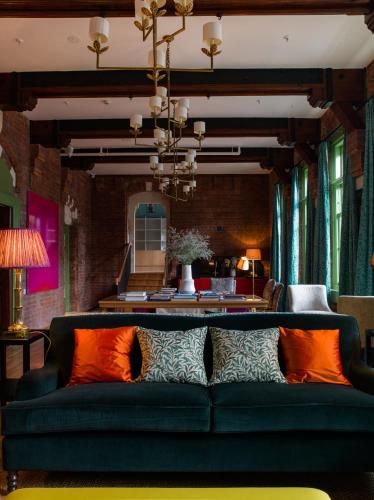 a living room with a green couch and orange pillows at The Observatory Hotel Christchurch in Christchurch