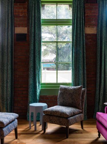 a living room with a chair and a window at The Observatory Hotel Christchurch in Christchurch