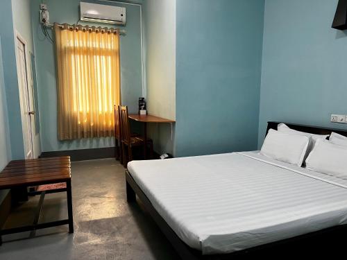 Schlafzimmer mit einem Bett, einem Tisch und einem Fenster in der Unterkunft Song of Travel Hostel in Nyaung Shwe