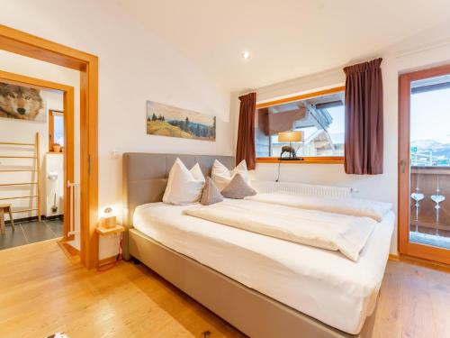 a large white bed in a room with windows at Eichenhof in Alpendorf