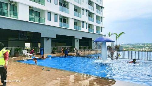 a swimming pool with a fountain in front of a building at CASA SAKURA Studio Vista Bangi with Wi-fi & Netflix in Kajang