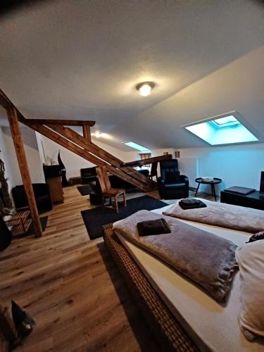 um quarto com 3 camas e cadeiras e uma clarabóia em Gästehaus Susanne em Oberstaufen