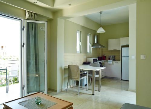 a kitchen and dining room with a table and chairs at Cosmos Apartments in Vasiliki