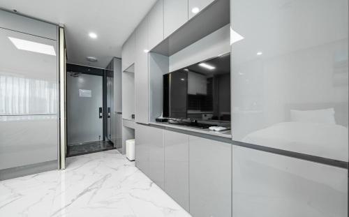 a white bathroom with a glass shower and a mirror at Songjeong Blue Castle Hotel in Busan