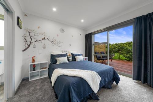 una camera con un letto e una grande finestra di Orange Blossom Cottage - Greytown Holiday Home a Greytown