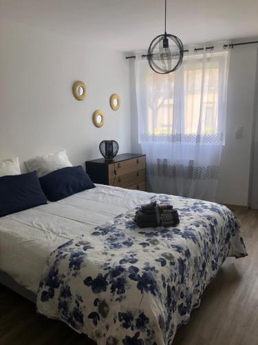 a bedroom with a bed with a blue and white blanket at LA PETITE MAISON DE TATATE in Longué