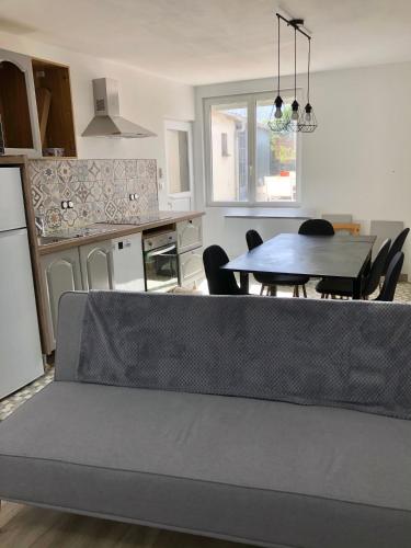 un salon avec une table et une cuisine dans l'établissement LA PETITE MAISON DE TATATE, à Longué