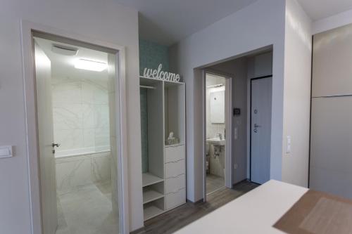 uma casa de banho com uma cabina de duche ao nível do chão e uma banheira em Coral Luxury Apartment em Siófok