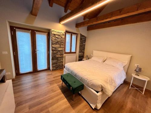 a bedroom with a large bed and wooden floors at Bed & Bike La Stalla in Masera