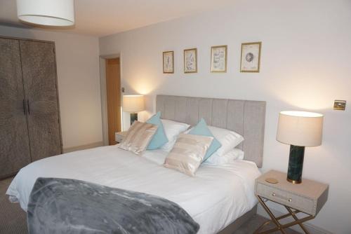 a bedroom with a large white bed with pillows at The Old Toll House in St Andrews