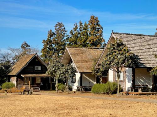 a couple of buildings with trees in the background at Log Park Dochidol Ranch in Jeju