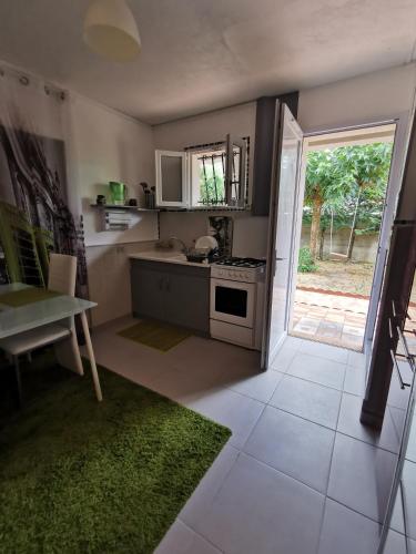 Il comprend une cuisine équipée d'une cuisinière et d'une table. dans l'établissement Petite maisonnette de plein pied, à Le Taillan-Médoc