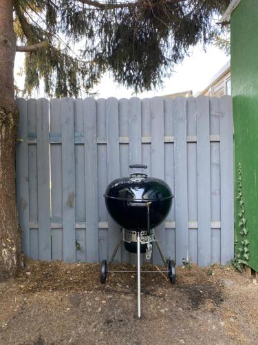 a grill on a stand in front of a fence at S-CHALET Camping mit Comfort im Schwarzwald in Steinach