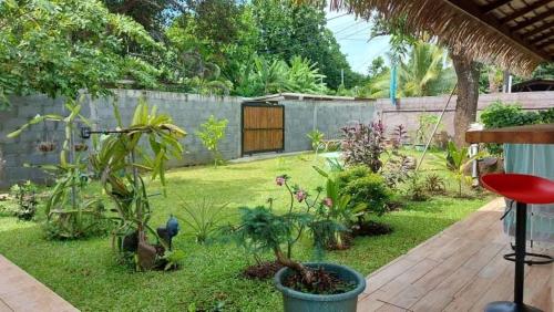 a backyard with a garden with plants and a fence at Tokerau Tahiti in Pirae