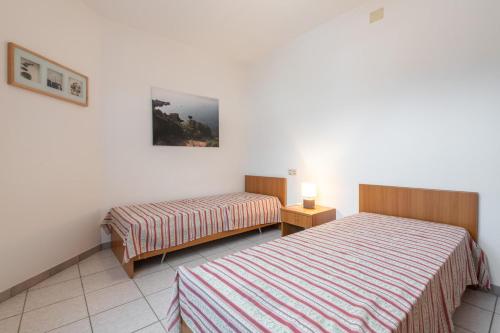 Una habitación de hotel con dos camas y un cuadro en la pared. en Casa Colonia 2, en SantʼAnna Arresi