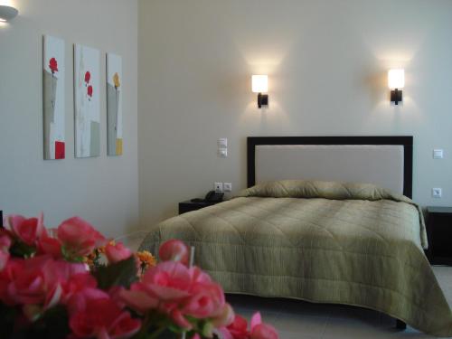 a bedroom with a bed with pink flowers in the foreground at Cabo Verde Hotel in Mati