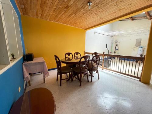 a dining room with a table and chairs and a balcony at Casa Los Patios in Jericó