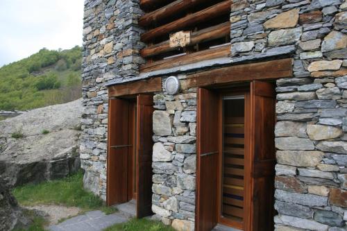 un edificio de piedra con dos puertas de madera. en Agri Scinghiöra en Brontallo