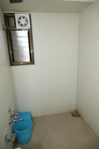 a bathroom with a window and a blue bucket at Hotel Dolphin Residency in Pātan