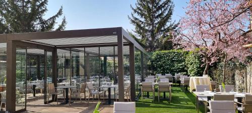 a dining area with tables and chairs in a garden at Erhardt Panzió in Sopron