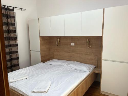 a bedroom with a bed with white sheets and white cabinets at Free Terrace in Piran