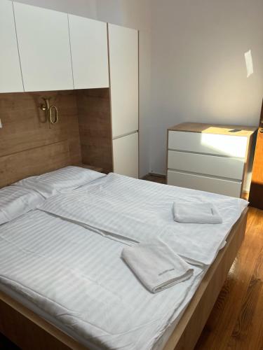 a bedroom with a bed with white sheets and white cabinets at Free Terrace in Piran