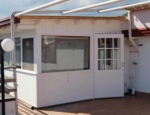 ヴィアグランデにあるAttico La Terrazzaの白いドアと窓のあるガレージ