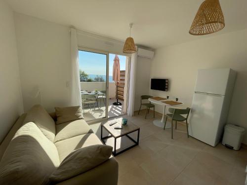- un salon avec un canapé, une table et un réfrigérateur dans l'établissement Résidence Marina Di Bravone, à Linguizzetta