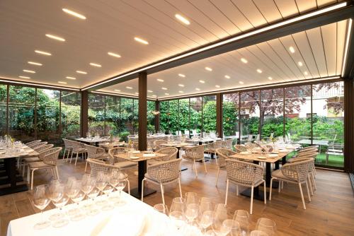 a dining room with tables and chairs and windows at Erhardt Superior Rooms in Sopron