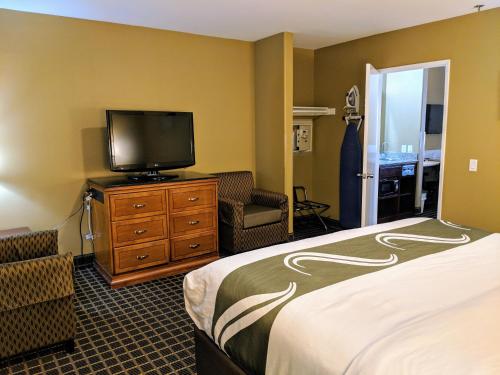 a hotel room with a bed and a flat screen tv at Quality Inn & Suites Westminster Seal Beach in Westminster