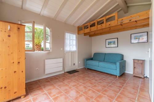 ein Wohnzimmer mit einem blauen Stuhl und einem Loft in der Unterkunft AUBEPINES 250 m de la grande plage in Hendaye