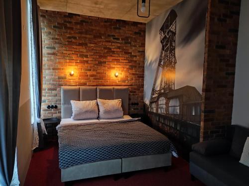 a bedroom with a bed and a brick wall at Apartmány u Bašty in Hlučín